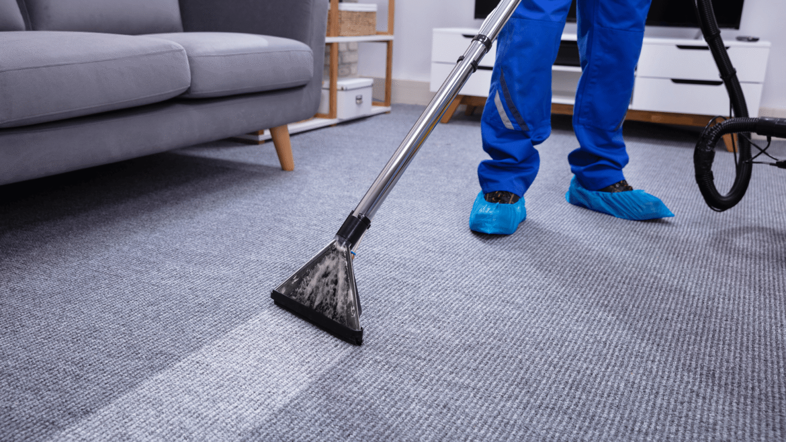 Professional carpet steam cleaning using hot water extraction in a living room.